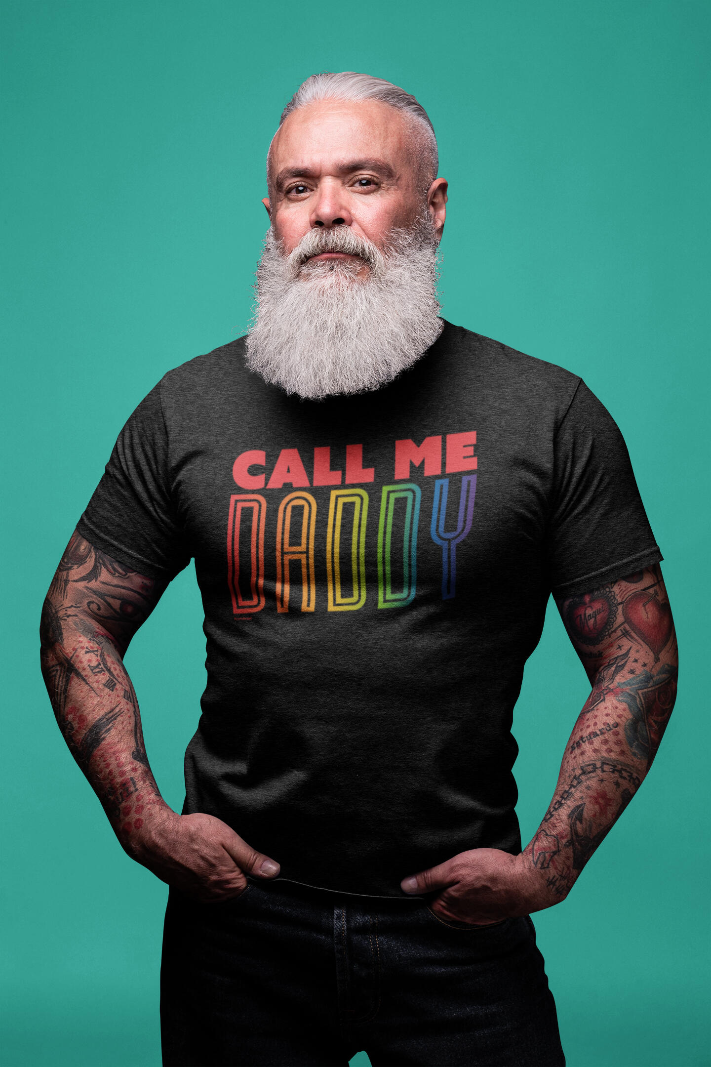 A silver daddy bear wearing a black t-shirt made by BearlyBrand that says "Call me Daddy" in the pride rainbow colors.